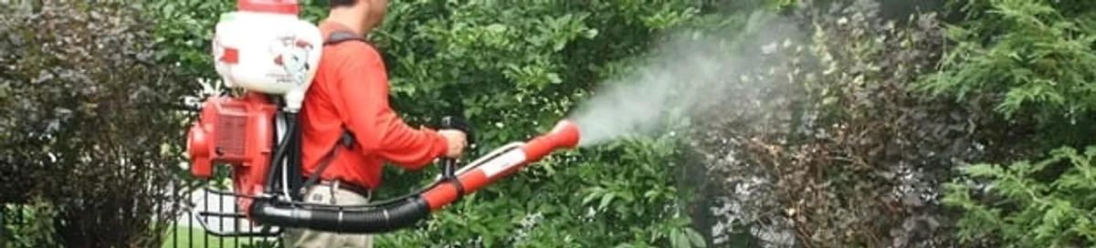 Mosquito control technician fogging shrubs and landscaping for mosquito treatment in Columbus, GA