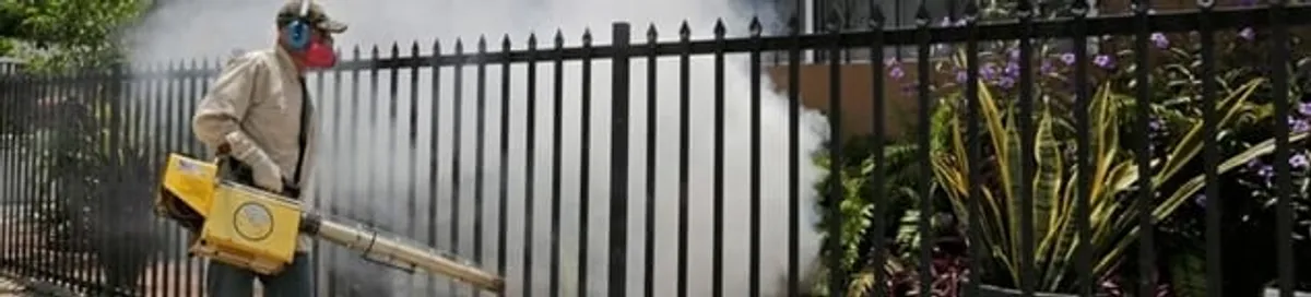 Mosquito control technician fogging a yard perimeter for mosquito reduction in Columbus, GA